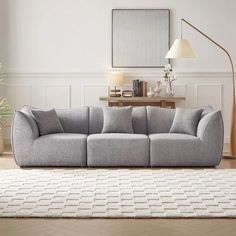 a living room with a gray couch and white rug