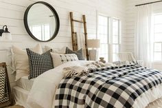 a bed with black and white checkered comforter in a bedroom next to a window