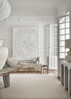 a large white vase sitting on top of a wooden table in a living room filled with furniture