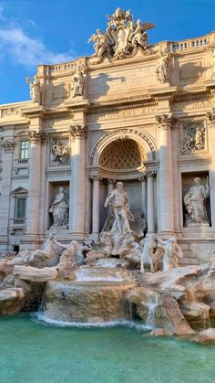 an ornate building with statues and fountains in front