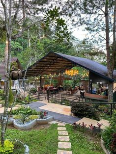 an outdoor patio with steps leading up to the deck and covered in greenery, surrounded by trees