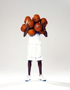 a person holding basketballs on their shoulders