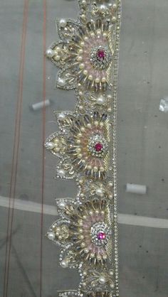 an elaborately designed headband is displayed in a store display case with beads and jewels