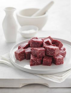 raw meat cubes on a white plate