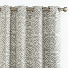 a curtain with an intricate design in grey and white colors, hanging on a metal rod