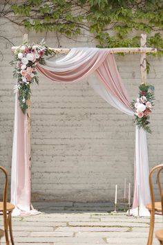 a wedding arch decorated with pink and white flowers