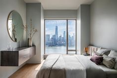 a bedroom with a large window overlooking the city