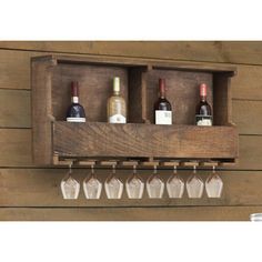 a wooden wine rack with six bottles and glasses hanging from it's sides on a wall