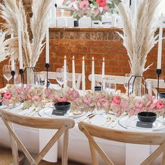 the table is set with flowers, candles and place settings for an elegant dinner party