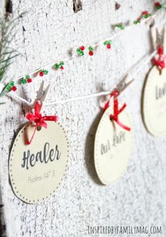 three tags are hanging on a wall with red and green ribbons attached to the tags