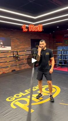 a man standing in a boxing ring talking on a cell phone