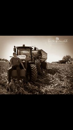 a man sitting on top of a tractor in a field