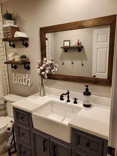 a white sink sitting under a bathroom mirror