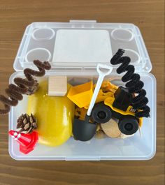 a plastic container filled with construction toys on top of a wooden table