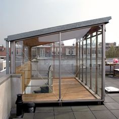 a glass walled room on the roof of a building