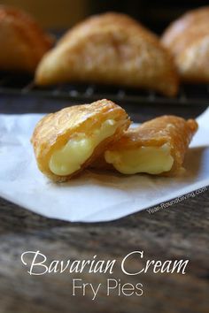 two croissants sitting on top of a piece of paper next to some other pastries