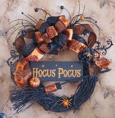 a halloween wreath with the words hocus pocus on it and decorations around it