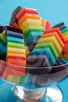 a bowl filled with rainbow colored candy on top of a table