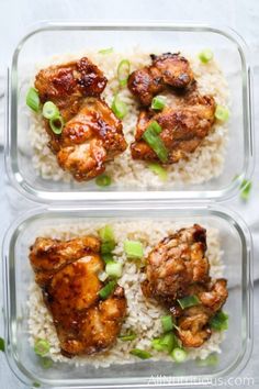 two plastic containers filled with rice and meat on top of each other, next to green onions