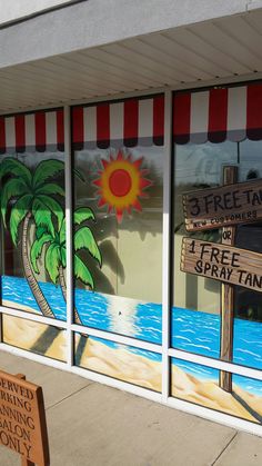 a store front window with painted signs and palm trees on the windows, along with a sign that says 3 free tacos