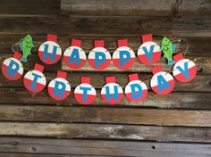 a happy birthday banner is hanging on a wooden wall with red, white and blue letters