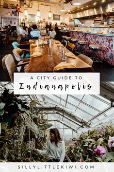 the inside of an indoor restaurant with plants and people sitting at tables in front of it