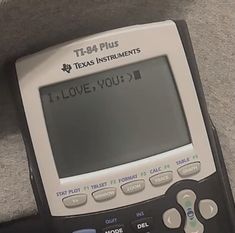 a calculator sitting on the floor with it's screen showing i love you