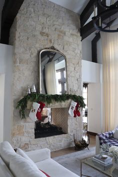 a living room filled with furniture and a fire place covered in christmas stockings next to a fireplace