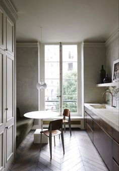 a dining room table and chairs in front of a window