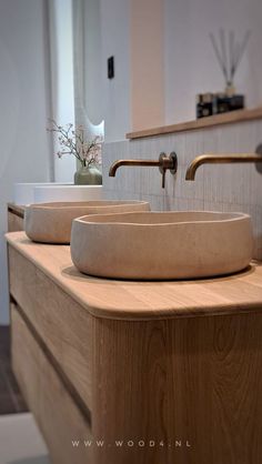 two sinks sit on top of a wooden counter