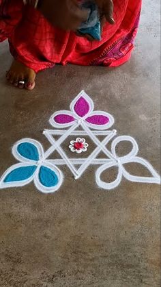 a woman kneeling on the ground drawing with chalk