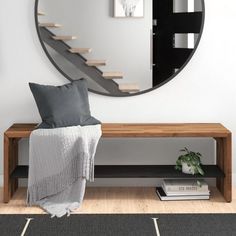 a living room with a large round mirror on the wall next to a wooden bench