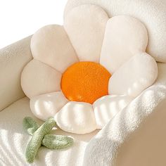 an orange and white flower sitting on top of a blanket