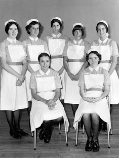 a group of women wearing aprons and sitting in chairs with their hands on their hips