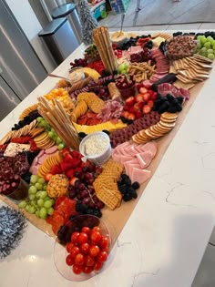 a large platter of fruit and crackers on a table in a kitchen area