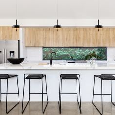 three stools are in front of the kitchen counter