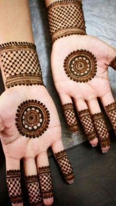 two hands with henna designs on them