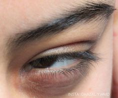 the eye of a woman with blue eyes and long eyelashes, looking down at the camera