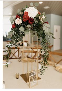 the centerpieces are decorated with red and white flowers, greenery, and candles