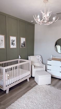 a baby's room with a white crib, chair and dresser in it