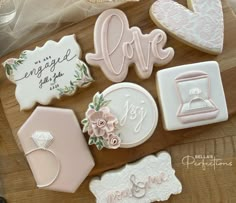 decorated cookies on a cutting board with wedding decorations