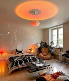 a bedroom with a bed, desk and chair in it's center area is lit up by colorful lights