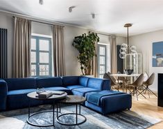 a living room filled with furniture and a blue sectional couch in front of a fireplace