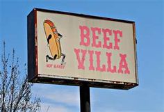 a sign that says beet villa with a surfboard on it's back