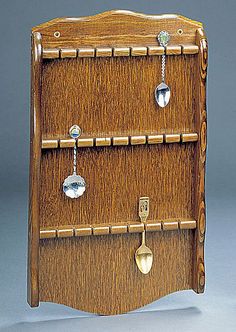 a wooden shelf with earrings hanging from it's sides and two hooks on each side