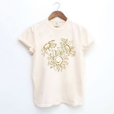 Looking for a cute versatile top to wear? Make sure to grab one of our Graphic tees! This soft and comfortable graphic tee is the perfect top for any outfit. It can be paired with biker shorts, jeans, or even a simple skirt/dress! This tee is true-to-size, so be sure to order your regular t-shirt size! If you are looking for a more oversized look, make sure to size up! Spring Bleached Relaxed Fit T-shirt, Relaxed Fit Bleached T-shirt For Spring, Bleached Relaxed Fit T-shirt For Spring, Cream Graphic Tee For Spring, Spring Soft-washed Cream Top, Soft-washed Cream Top For Spring, Spring Cream Soft-washed Tops, Spring Cream Soft-washed Top, Spring Cream Top With Screen Print