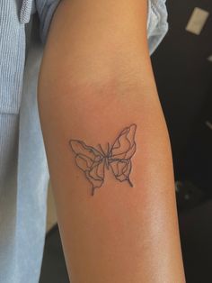 a woman's arm with a butterfly tattoo on the left side of her arm