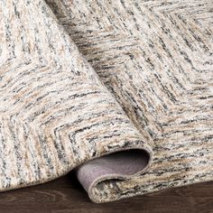 close up view of an area rug with wood flooring and wooden floors in the background