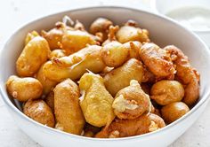 a white bowl filled with fried food on top of a table