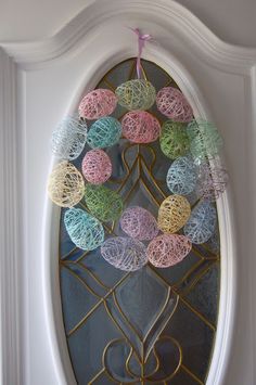 an easter egg wreath hanging on the front door